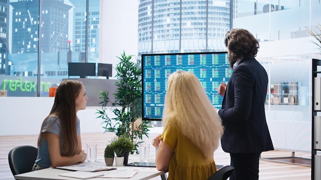 People working collaboratively in a modern office, reviewing financial documents and discussing tax strategies, with a digital display showing projections of tax savings and liabilities.