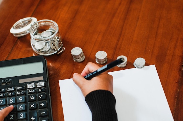 A hand filling out Tax Form 8812 with a pen, focusing on the section where child information is entered. A calculator and supporting documents are arranged nearby.