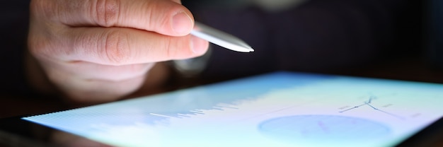 A close-up of a person's hands entering data into a financial planning software on a tablet, focusing on HSA contributions and projections.