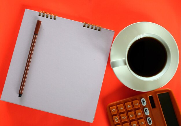 A close-up photo of a form 1099-NEC with a pen resting on it. There is a calculator in the background and a cup of coffee. The lighting is warm and inviting.