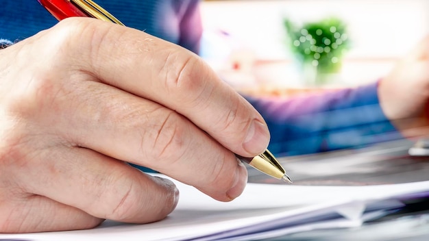 A close-up shot of hands filling out a retirement claim form, highlighting the precision and attention to detail required. The hands hold a pen, hovering over the document, with a professional yet comforting ambiance.