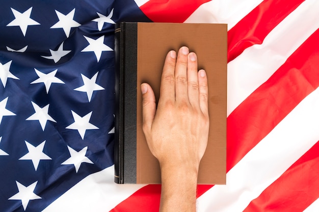 A close-up of a hand placing a ballot in a ballot box, with the American flag subtly visible in the background, symbolizing the democratic process and the importance of protecting voting rights.