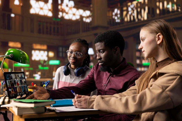 A diverse group of students studying together in a modern library setting, representing the goal of saving for higher education.