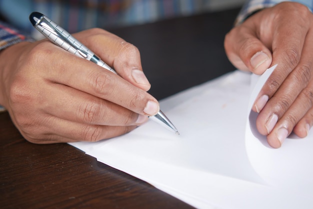 A close-up shot of a hand signing a document with the words