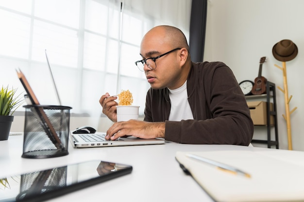 A person sitting at a desk, attentively working on a computer while researching federal job training programs. The screen displays a government website with detailed information about program requirements and application procedures.